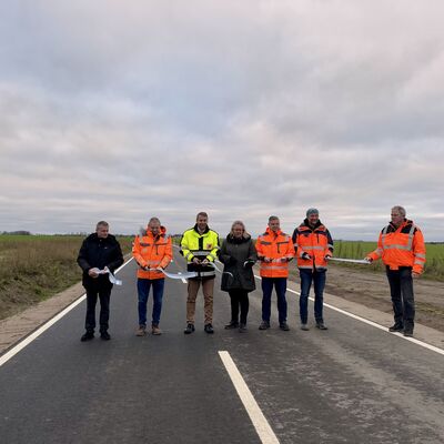 Foto: (v.l.n.r.): Udo Sch&ouml;nherr (LK V-G), Jens Gebhard (GP Verkehrswegebau), Landrat Michael Sack, Kirsten Breitsprecher-Kranz (B&uuml;rgermeisterin Gemeinde Neuenkirchen), Sven Wei&szlig;flog (Amt Landhagen), Matthias Kr&uuml;ger (IPO Unternehmensgruppe), Jens K&ouml;ppen (LK V-G)